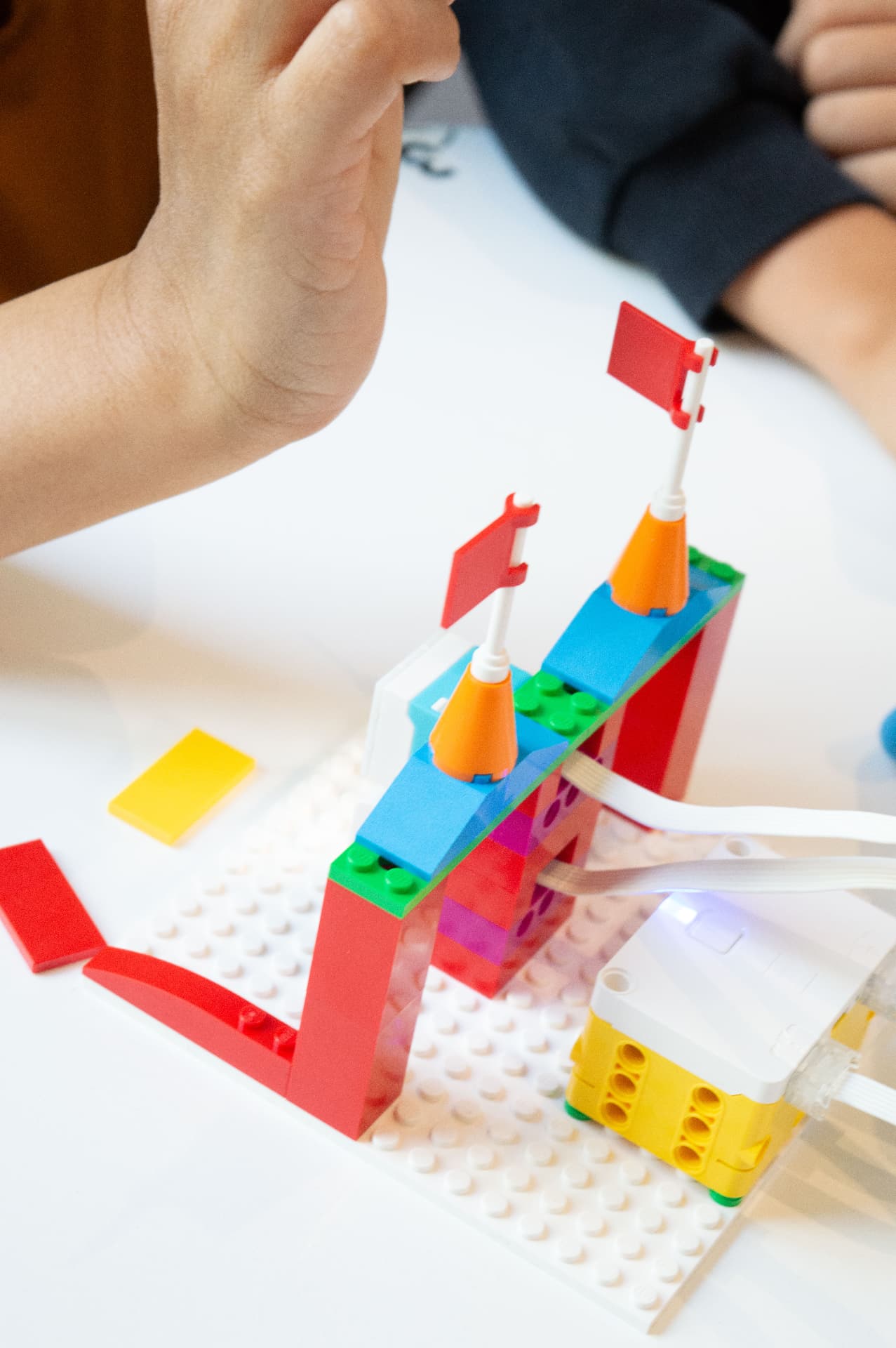 A child adjusting a motorised model with flags on a building plate