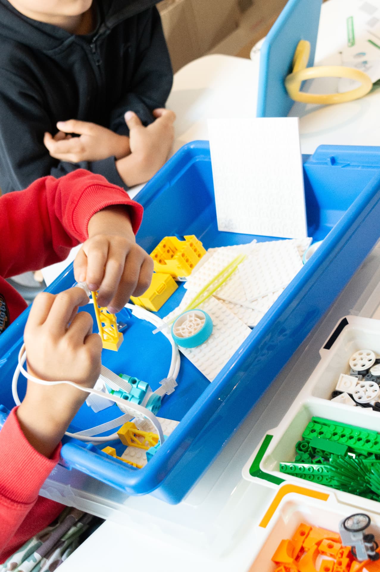 Children assembling a robot together during a Kid Saclai camp
