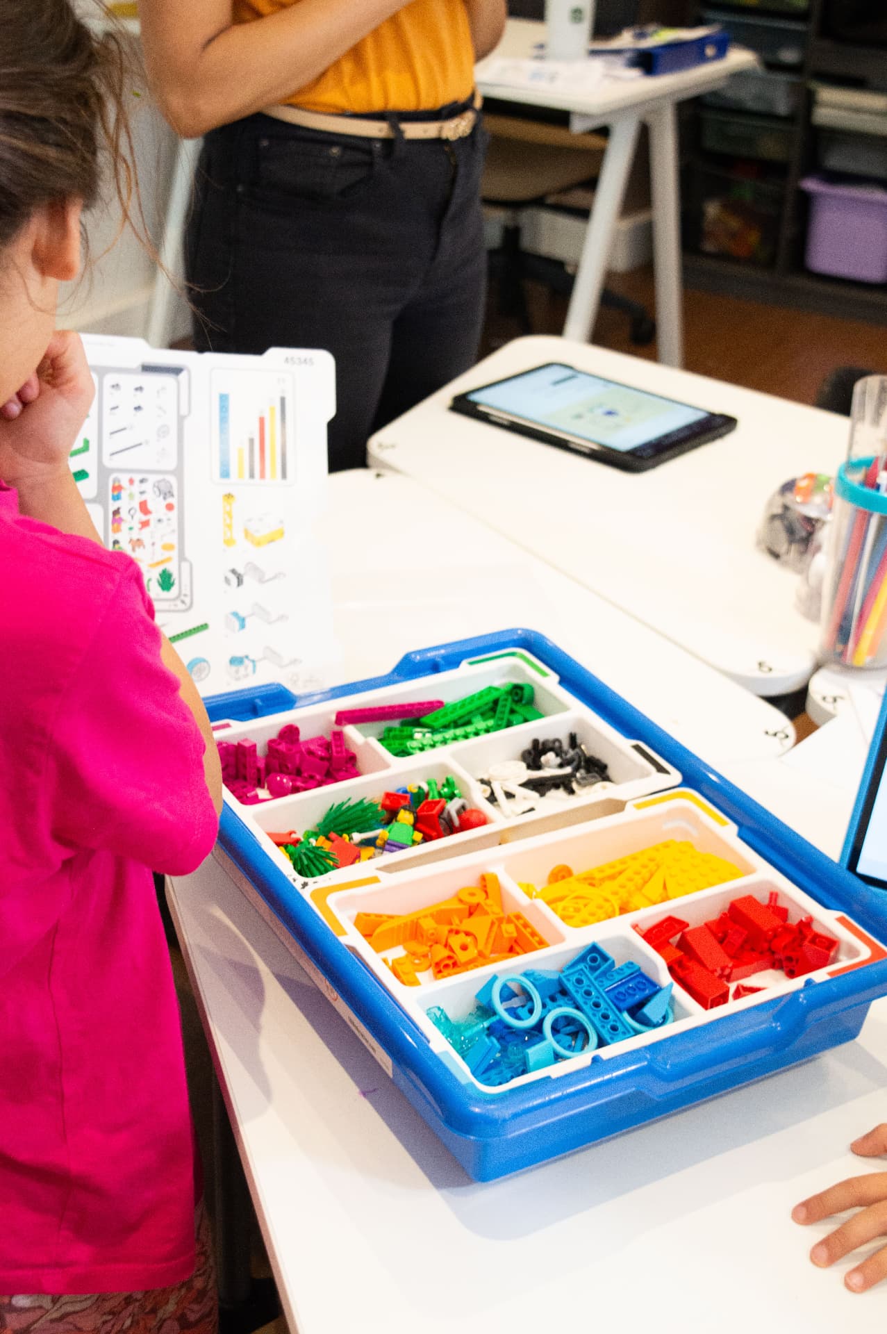 A child working beside a large organised robotics kit